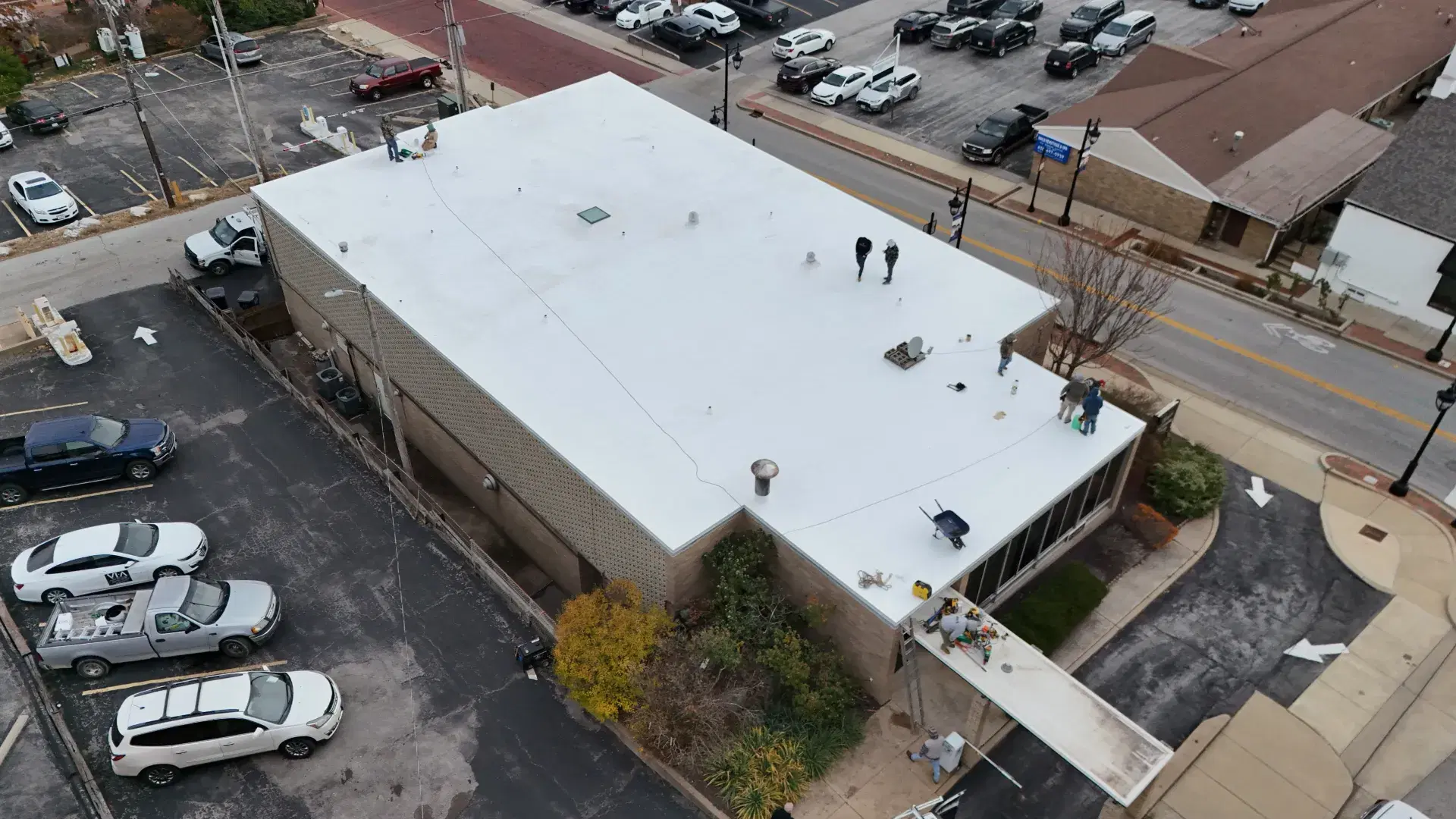 Aerial view of the crew working on a white flat roof on a commercial building